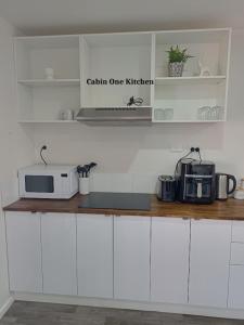 a kitchen with white cabinets and a microwave at Minyip Caravan Park in Minyip