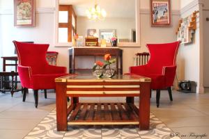 salon z czerwonymi krzesłami i stołem w obiekcie Hôtel Majestic w Lourdes