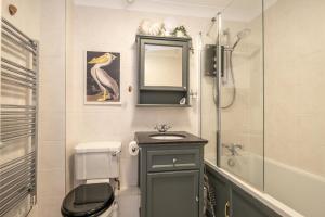 Un baño con lavabo, inodoro y ducha. en 3 St Johns Court - Aldeburgh Coastal Cottages, en Aldeburgh 12 fotos más
