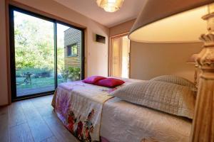 Un pat sau paturi într-o cameră la L'Ecrin de Bois - Maison d'architecte avec Spa sur un grand terrain arboré