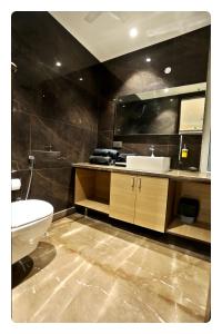 a bathroom with a sink and a toilet and a mirror at KRYC Luxury Living near Indraprastha Apollo Hospital in New Delhi