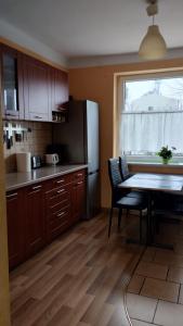 a kitchen with a table and a refrigerator at Apartament Lyszcze 7 Centrum Parking Balkon Blisko rynku Spokojna okolica in Tarnowskie Góry +10 photos