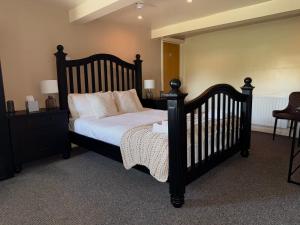a bedroom with a black crib with pillows at The Five Bells Inn Accommodation in Claypole