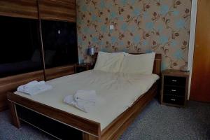 a bedroom with a bed with two towels on it at The Five Bells Inn Accommodation in Claypole