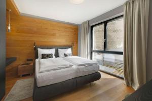 una camera da letto con un letto grande e una grande finestra di Alpine Chic - Fireplace Views & Ski Resorts a See