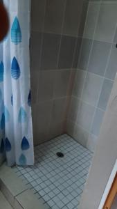 a shower with a white and blue shower curtain at Central Cottages in Soweto