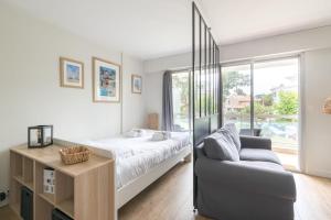 a bedroom with a bed and a couch at L'EVASION - 500m plage - Parking - Wifi in La Baule