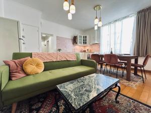 a living room with a green couch and a table at E Gambetta T3 au pied de l avenue de champagne in Épernay +26 photos