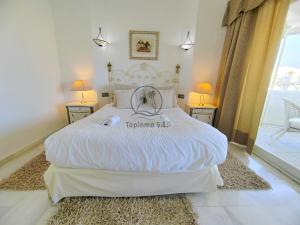 1 dormitorio con 1 cama blanca con 2 mesas y 2 lámparas en Palacio de Poniente with views, en Benalmadena Costa 25 fotos más