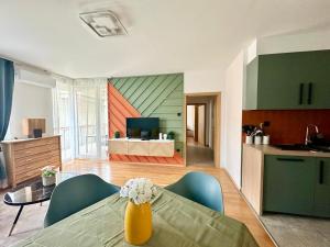 a living room with a table and a kitchen at Akácfa Apartment by Chivi II FreeParking in Budapest