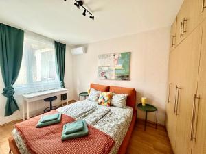 a bedroom with a bed with two green pillows on it at Akácfa Apartment by Chivi II FreeParking in Budapest