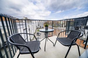a patio with two chairs and a table on a balcony at APARTIA Apartment Brno center in Brno