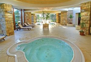 a hot tub in a room with a stone wall at Stunning Spacious Studio with Garden Terrace Gozo in Sannat