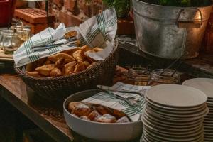 a basket of bread and a bowl of pastries on a table at Home Hotel Katajanokka in Helsinki