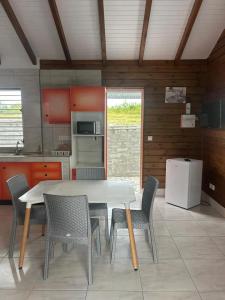 a kitchen with a table and chairs in a room at Chalet cosy à Saint-François avec piscine privée in Saint-François