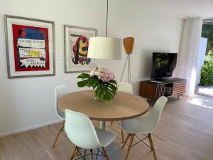 Un comedor con una mesa con un jarrón de flores. en Ascona Casa Azzurra, en Ascona
