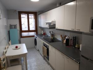 ビヌエサにあるCasa Romarの白いキャビネットとシンクとテーブルのあるキッチン