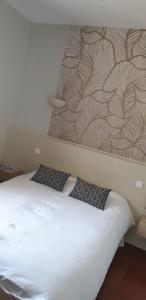 a bed with two pillows on top of it at Le Tournedos in Lézignan-Corbières