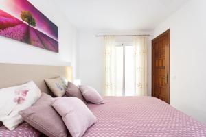 a bedroom with a pink bed with pink pillows at Santana Sunshine by Sunkeyrents in Santiago del Teide