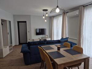 a living room with a blue couch and a table at V&S apartments 1 in Sliven