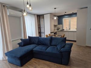 a living room with a blue couch and a kitchen at V&S apartments 1 in Sliven +20 photos