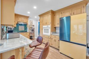 a kitchen with wooden cabinets and a blue refrigerator at Upscale Escape - Game Room & Spa-Like Baths home in Richmond