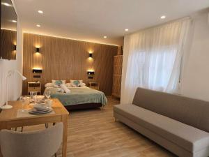 a bedroom with a bed and a couch and a table at El Nogal Home in Málaga