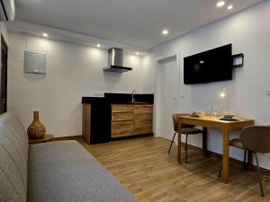 a living room with a table and a flat screen tv at El Nogal Home in Málaga