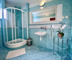 a blue bathroom with a sink and a shower at Privat Horec in Malý Slavkov +43 photos