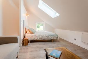 a bedroom with a bed and a skylight at Gîte Avec Jacuzzi Chic & Cosy entre Caen et la Mer en Normandie in Biéville-Beuville