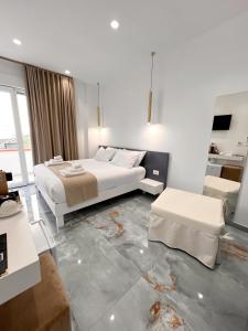 Un dormitorio blanco con una cama y una sala de estar. en Suite 14, en Scalea