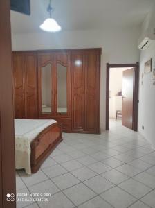 a bedroom with a bed and wooden cabinets at Casa Cesa in Selargius