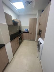 马斯喀特Muscat bay Zaha 2 bedroom的厨房配有木制橱柜、洗衣机和烘干机