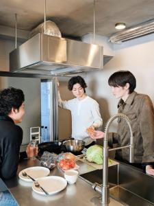 three people standing in a kitchen preparing food at ART HOTELS SHIBUYA in Tokyo