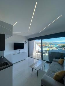 a living room with a couch and a tv and a table at Villa San Sebastian-Baška in Baška