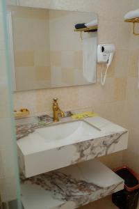 a bathroom with a white sink and a mirror at موتيل رامي سكاي Motel Rami Sky in Erbil