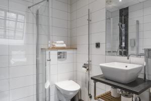 a white bathroom with a sink and a toilet at The More Hotel Lund in Lund +67 photos