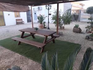 a picnic table and bench on a patch of grass at Caseta del Delta de l'Ebre in Sant Jaume d'Enveja