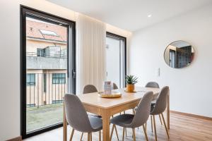 a dining room with a table and chairs and a large window at GuestReady – The Mythic Apartments in Porto