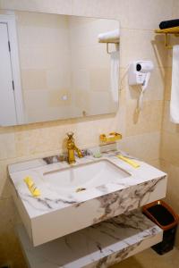 a bathroom with a marble sink and a mirror at موتيل رامي سكاي Motel Rami Sky in Erbil