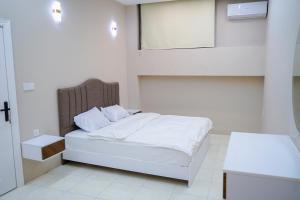 a bedroom with a white bed and a mirror at موتيل رامي سكاي Motel Rami Sky in Erbil