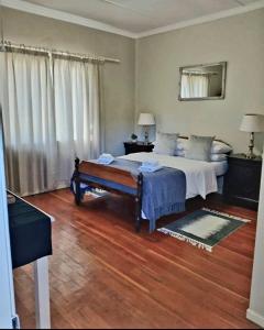 a bedroom with a bed and a bench in it at Karoorus Mossie -Loxton Overnight Stay in Loxton