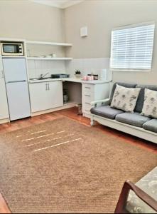 a living room with a couch and a kitchen at Karoorus Mossie -Loxton Overnight Stay in Loxton