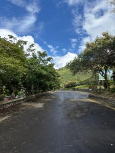 an empty street with trees on the side of the road at Urban oasis in Port Louis