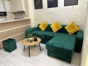 a living room with a green couch and a table at ROYAL MIRAGE Militari Residence in Chiajna