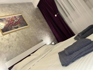 a bedroom with a bed with a picture on the wall at ROYAL MIRAGE Militari Residence in Chiajna