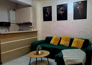 a living room with a green couch and a table at ROYAL MIRAGE Militari Residence in Chiajna +12 photos