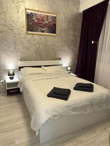 a bedroom with a white bed with two towels on it at ROYAL MIRAGE Militari Residence in Chiajna