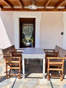 a white table and chairs with a table and a window at Koeni House in Argalasti