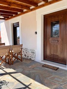 a wooden door and a bench in front of a house at Koeni House in Argalasti